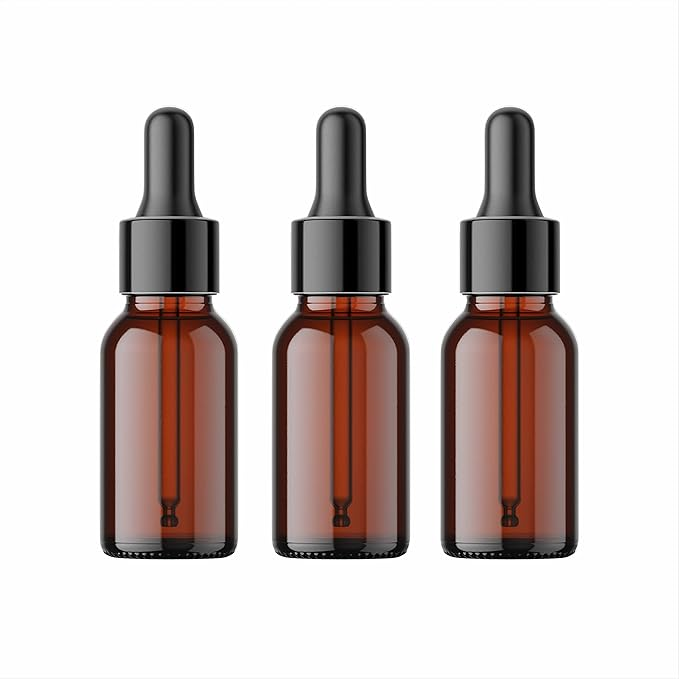 Two transparent glass dropper bottles with golden caps and white droppers, one small and one slightly larger, displayed on a plain white background. The bottles are empty, showcasing their clear design and minimalist aesthetic suitable for cosmetic or essential oil packaging.